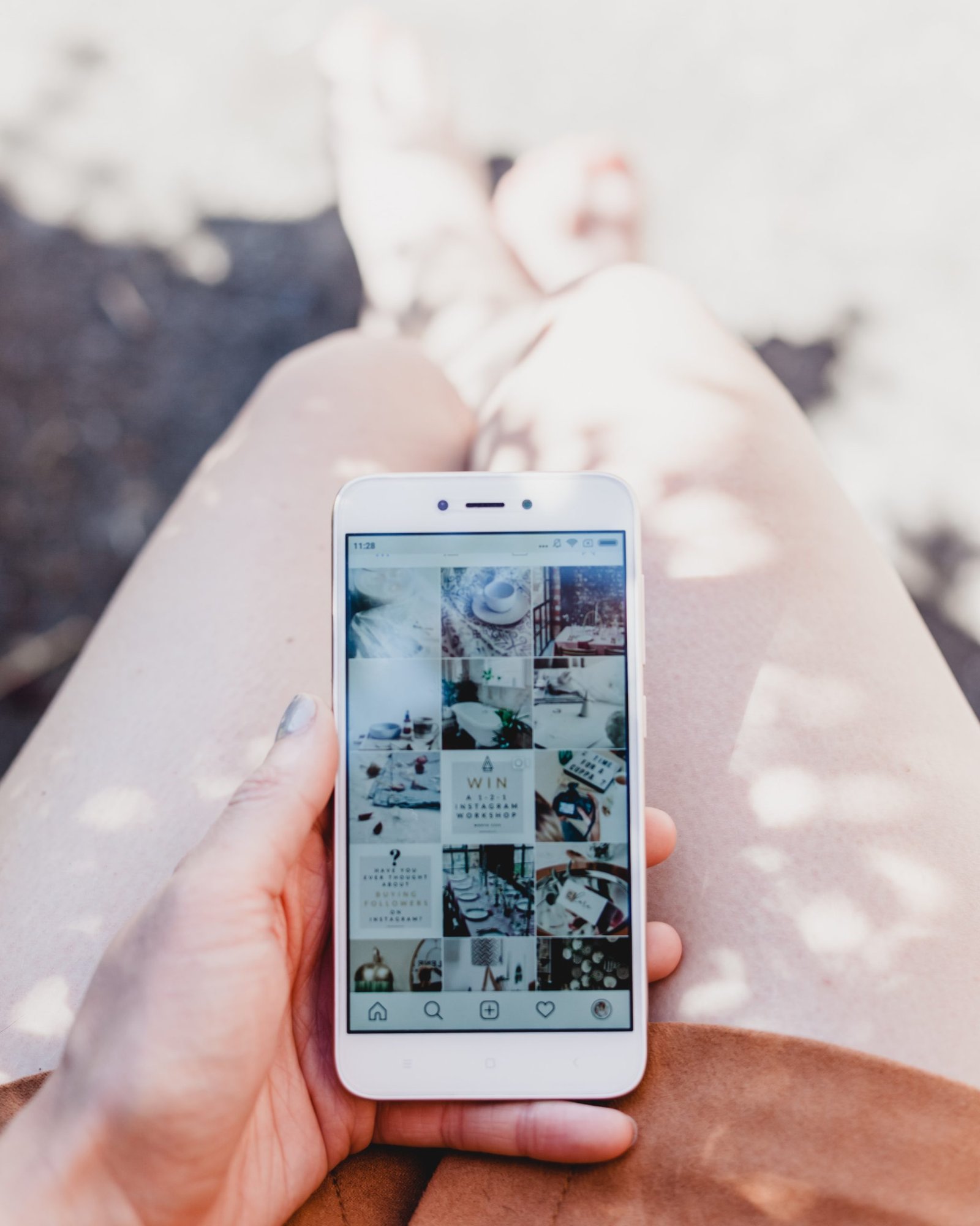person holding white smartphone showing Instagram feed